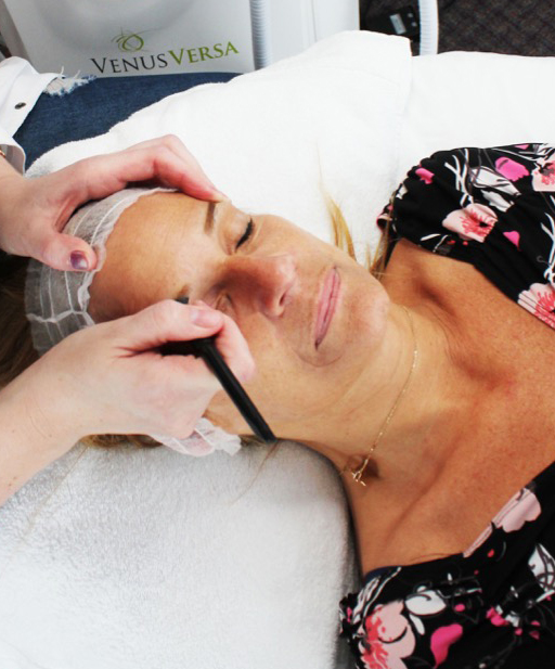 Lana drawing the brow shape on a client during treatment
